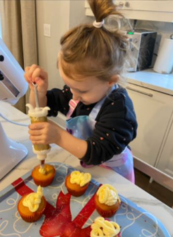 Child using a piping bag to add frosting
